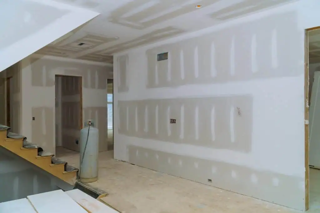 Interior drywall installation with unfinished walls and ceiling in a residential space.