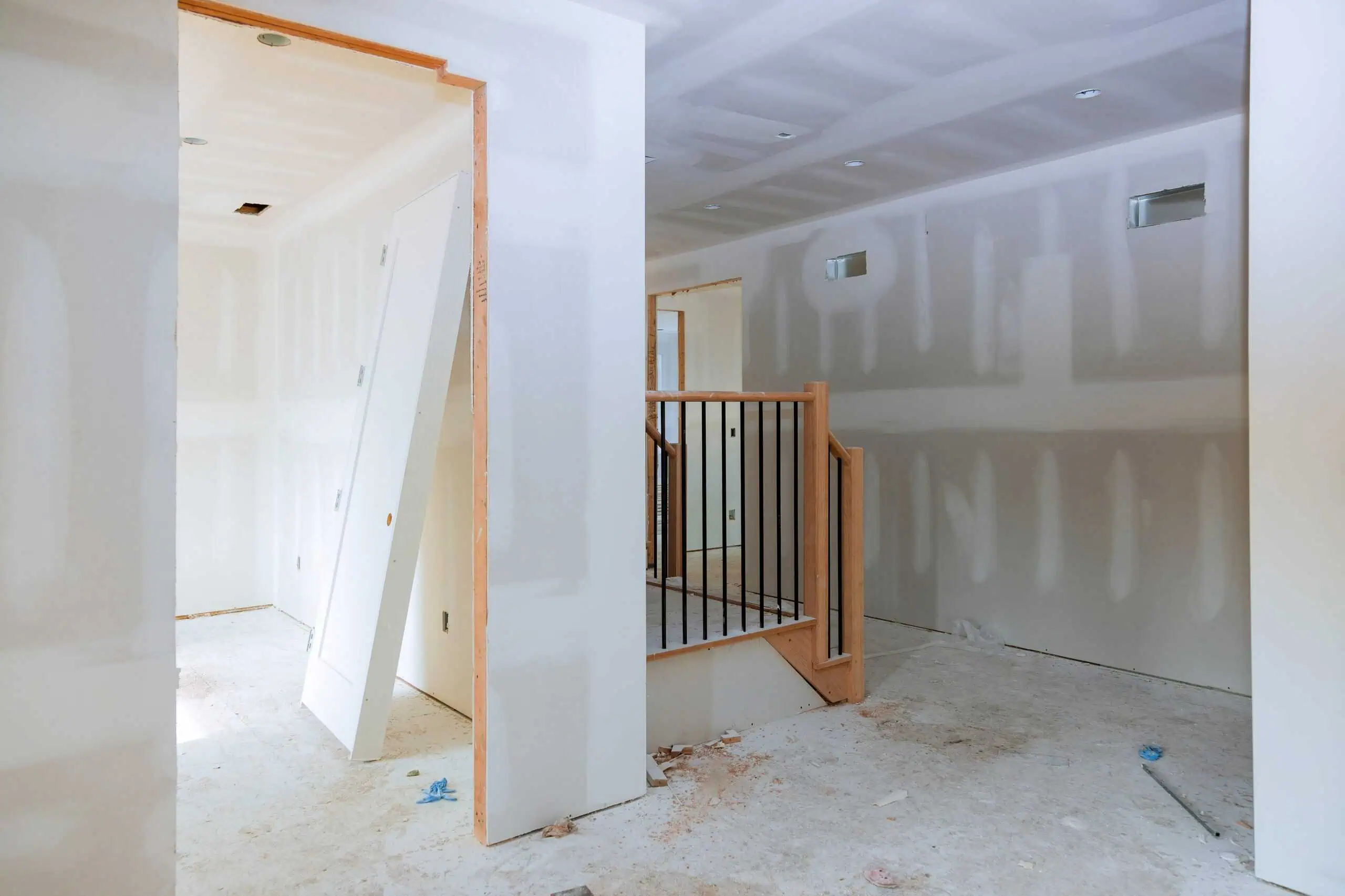 Drywall installation in a residential interior with unfinished walls and ceiling.