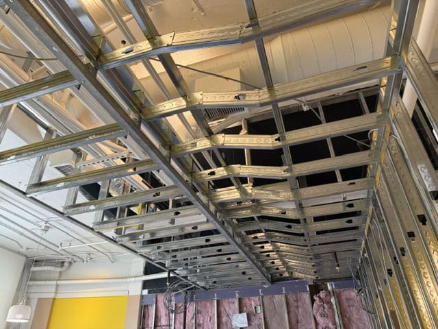 Construction site with metal framing and drywall framework.
